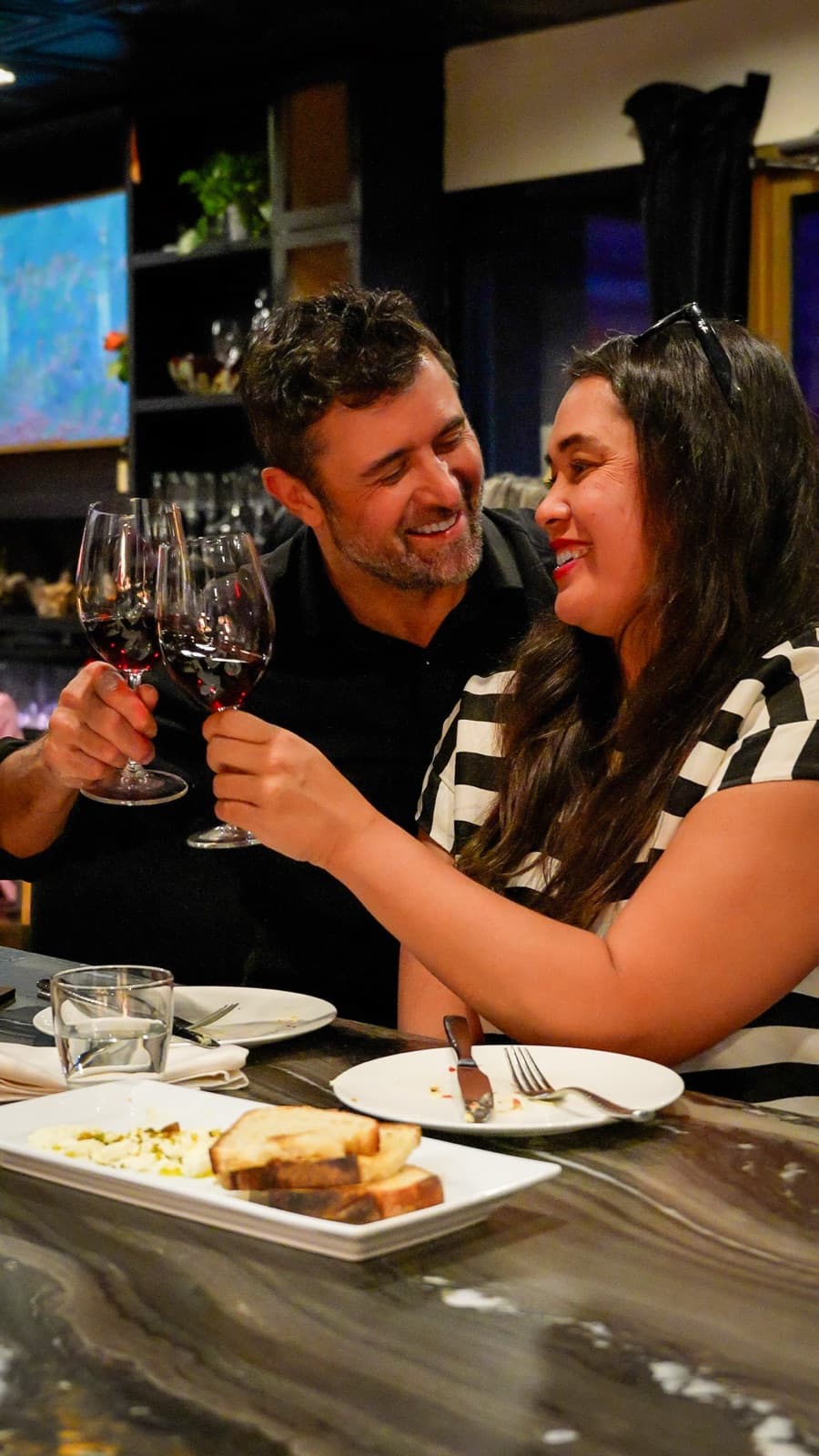 Guests toasting over glasses of red wine